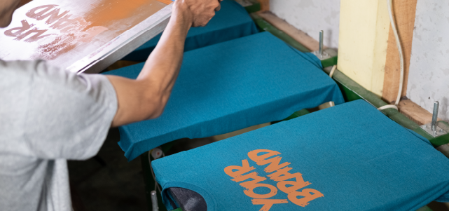 a line of shirts being printed upon