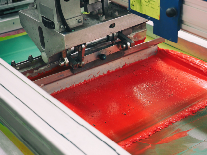 red ink being pressed through a screen 