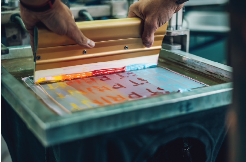 screen printer pushing ink through a screen 